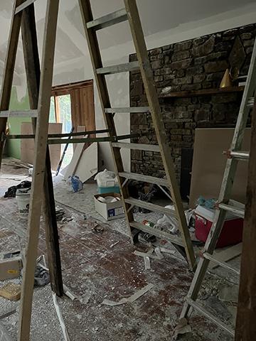 Ladders and building materials around an unfinished fireplace